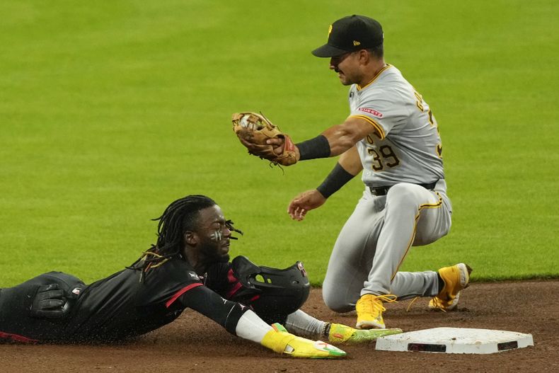 Elly De La Cruz, izquierda, llega a salvo para robarse segunda base mientras Nick Gonzales, derecha, segunda base de los Piratas de Pittsburgh, hace el intento de retirarlo durante la cuarta entrada, el viernes 20 de septiembre de 2024, en Cincinnati. (AP Foto/Carolyn Kaster)