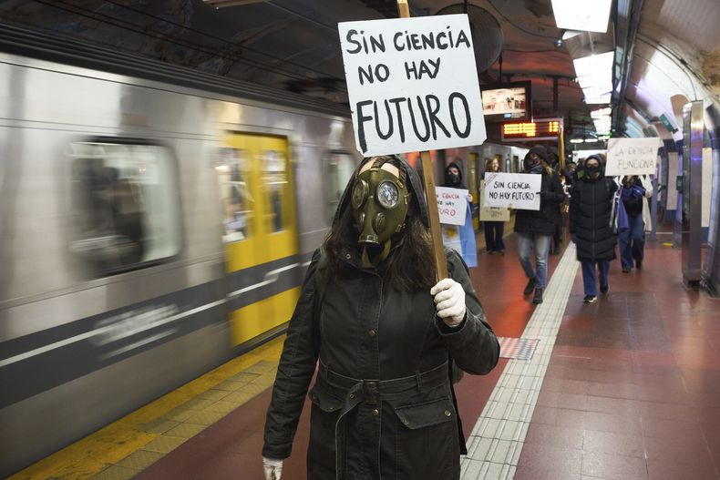 Una mujer porta una cartel en el subterráneo (metro) que reza Sin ciencia no hay futuro, durante una protesta de trabajadores del Consejo Nacional de Investigaciones Científicas y Técnicas en Buenos Aires, Argentina, el miércoles 28 de mayo de 2025. (AP Foto/Rodrigo Abd)