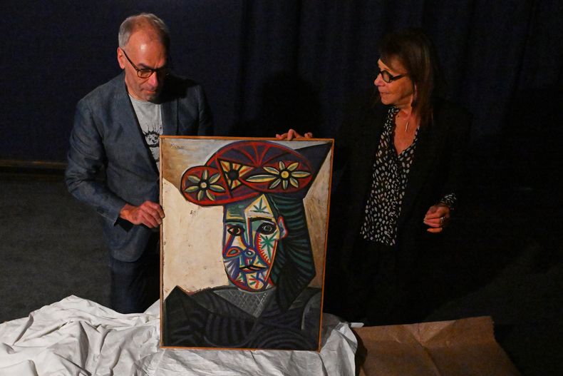 La experta en arte Agnes Sevestre-Barbe (derecha) y el encargado de subastas Christophe Lucien exhiben un cuadro redescubierto de Picasso, Busto de mujer con sombrero floreado, el miércoles 22 de octubre de 2025 en París. El retrato, creado en 1943 y subastado el viernes en París, fue adquirido en 1944 y representa a su pareja, Dora Maar. (Foto AP/Emma Da Silva)
