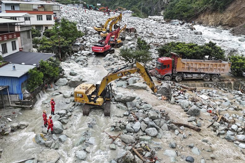 En esta imagen aérea publicada por la agencia de noticias Xinhua, rescatistas con excavadoras trabajan para restablecer el tráfico en la autopista nacional 318 tras deslaves e inundaciones en el poblado de Ridi, en la ciudad de Kangding, Prefectura Autónoma Tibetana de Garze, en el suroeste de la provincia china de Sichuan, el domingo 4 de agosto de 2024. (Liu Kun/Xinhua via AP)