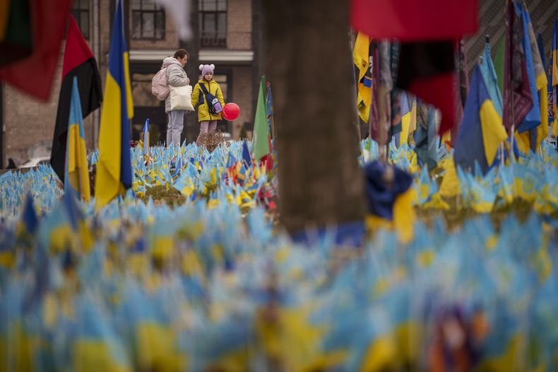 Un niño con un globo en la mano observa el 14 de marzo de 2024 un altar instalado en Kiev, Ucrania, para soldados muertos en la guerra. (AP Foto/Vadim Ghirda)