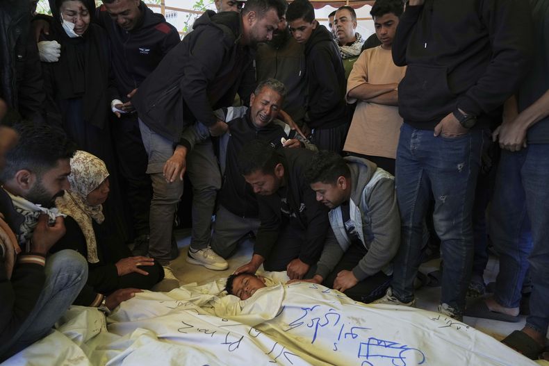 Varias personas lloran sobre el cadáver del niño palestino Mohammad Abu Nada, fallecido en un ataque aéreo del ejército israelí, durante su funeral en Jan Yunis, en el sur de Gaza, el 19 de abril de 2025. (AP Foto/Abdel Kareem Hana)