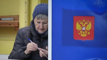 Una mujer comprueba si un bolígrafo escribe antes de rellenar su boleta para las elecciones presidenciales, en un centro de votación el 15 de marzo de 2024, en San Petersburgo, Rusia. (AP Foto/Dmitri Lovetsky)