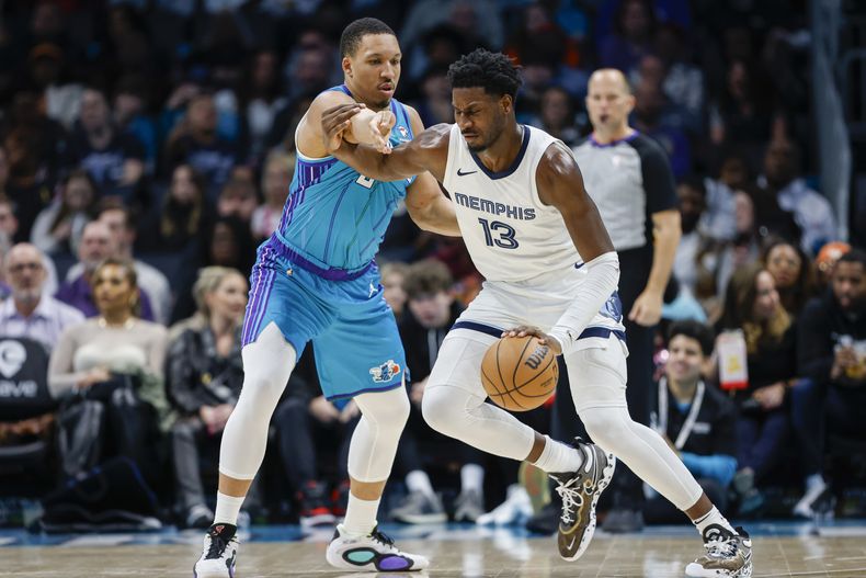 El alero de los Grizzlies de Memphis, Jaren Jackson Jr. (13), conduce contra el alero de los Hornets de Charlotte, Grant Williams, a la izquierda, durante la segunda mitad deL partido de baloncesto de la NBA en Charlotte, Carolina del Norte, el sábado 10 de febrero de 2024. (AP Foto/Nell Redmond)