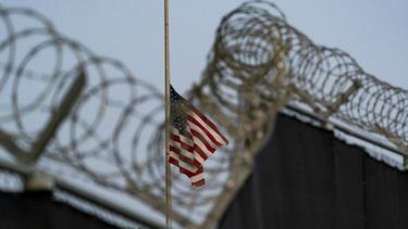 En esta imagen del 29 de agosto de 2021 revisada por oficiales militares de Estados Unidos, una bandera ondea a media asta en una vista desde Camp Justice, en la Base Naval de Bahía de Guantánamo, Cuba. (AP Foto/Alex Brandon, Archivo)