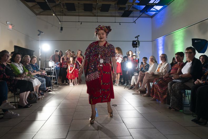 La diseñadora guatemalteca Elena de León camina por la pasarela durante un desfile de modas en el que se presentaron sus textiles guatemaltecos, el viernes 12 de mayo de 2023, en Brownsville, Texas. De León, nacida en Guatemala, combinó técnicas indígenas de tejido, diseño moderno de ropa y colorida historia de su país natal en esa exhibición, la cual ofreció una muestra no sólo de su visión artística, sino un trabajo de madres guatemaltecas, incluidas algunas que viven en Estados Unidos y otras que se quedaron en su país para apoyar a sus familias. (AP Foto/Julio Cortez)