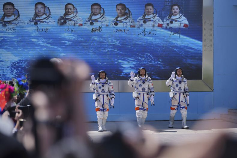 Los astronautas chinos de la misión Shenzhou 20 --(de derecha a izquierda) Chen Zhongrui, Chen Dong y Wang Jie-- saludan durante el acto para despedir a su misión espacial tripulada, en el centro de lanzamiento satelital de Jiuquan, en el noroeste de China, el 24 de abril de 2025. (AP Foto/Andy Wong)