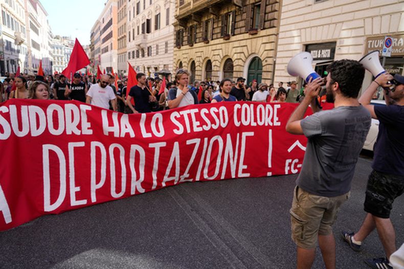 Varias personas portan una pancarta en italiano con el lema La piel y el sudor tienen el mismo color, no a la deportación durante una marcha en Roma, el sábado 13 de junio de 2026, para protestar contra el paquete de medidas de seguridad y migración de Italia, que incluye un plan de bonificación por repatriación para migrantes. (Foto AP/Gregorio Borgia)